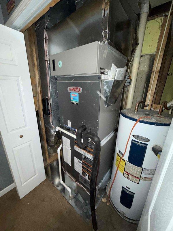 Completed installation of a Lennox 2-ton 19 SEER heat pump system with air handler and integrated 2-zone control system. Installed properly sealed ductwork with appropriate transitions and connections as evidenced by foil-taped seams. System was placed in a utility area alongside existing water heater with all manufacturer specifications followed for clearances and connections.
