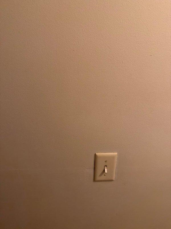 Responded to a service call regarding water leakage from shower through wall, affecting a hallway light switch. Conducted visual inspection of the affected area, documented current condition with photos. No visible water damage observed on wall surface or switch plate at time of inspection.