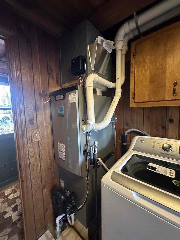 Successfully installed a complete 2-ton, 18 SEER Lennox HVAC system at a log cabin-style residence. The outdoor condensing unit was properly positioned on a concrete pad with appropriate electrical connections and disconnect box. Indoor installation included furnace unit with PVC ventilation system in the utility room, completing the full system replacement as specified in the sales order.