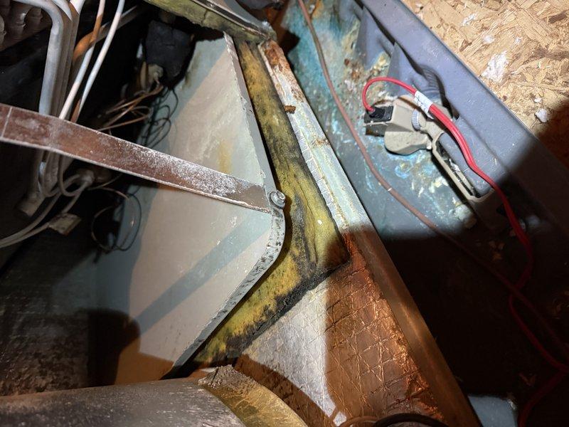 Performed diagnostic assessment on 18-year-old HVAC system after customer reported non-functioning heat strips. Inspection revealed significant corrosion and rust throughout the air handler interior, with visible moisture damage and deterioration of metal components. Examination of the electrical control panel showed signs of condensation with potential electrical hazards, confirming multiple heat strips have failed due to age-related wear and system deterioration.