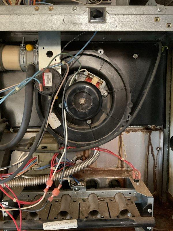 Responded to no heat call for 20-year-old Arcoaire gas furnace that was short cycling and blowing cool air. Upon inspection, found significant corrosion on heat exchanger and deterioration of blower assembly components. Diagnosed failed pressure switch and compromised heat exchanger requiring full system replacement. Temporarily restored operation by cleaning contacts and adjusting pressure switch to allow customer time to consider replacement options. Recommended immediate upgrade due to safety concerns and inefficiency of current system.