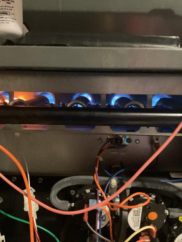 Upon arrival, diagnosed intermittent heating issue persisting after previous flame sensor replacement. Observed proper burner ignition with consistent blue flames but system continued to cycle off prematurely. Identified faulty pressure switch causing improper operation. Replaced pressure switch, verified proper system operation through multiple heating cycles, and confirmed normal flame pattern and gas combustion.