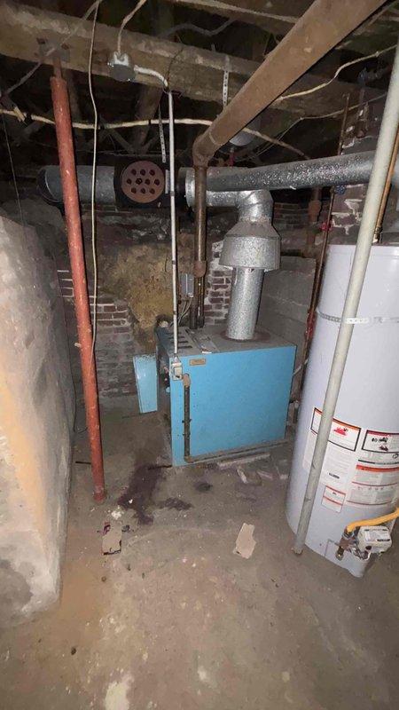 Conducted replacement estimate for non-functional boiler system in 5000 sq ft residence. Inspected existing equipment including aging blue boiler unit with metal exhaust ductwork and adjacent water heater. Noted exterior natural gas meter installation with PVC piping showing exposure to winter elements and weathered building exterior. Discussed potential replacement options and repair alternatives with homeowner.