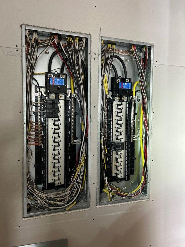 Conducted a comprehensive generator installation assessment, examining the existing dual circuit breaker panels with exposed internal components and evaluating the exterior electrical service panel mounted on brick wall. Documented current electrical infrastructure to determine appropriate generator specifications and connection requirements for the property.