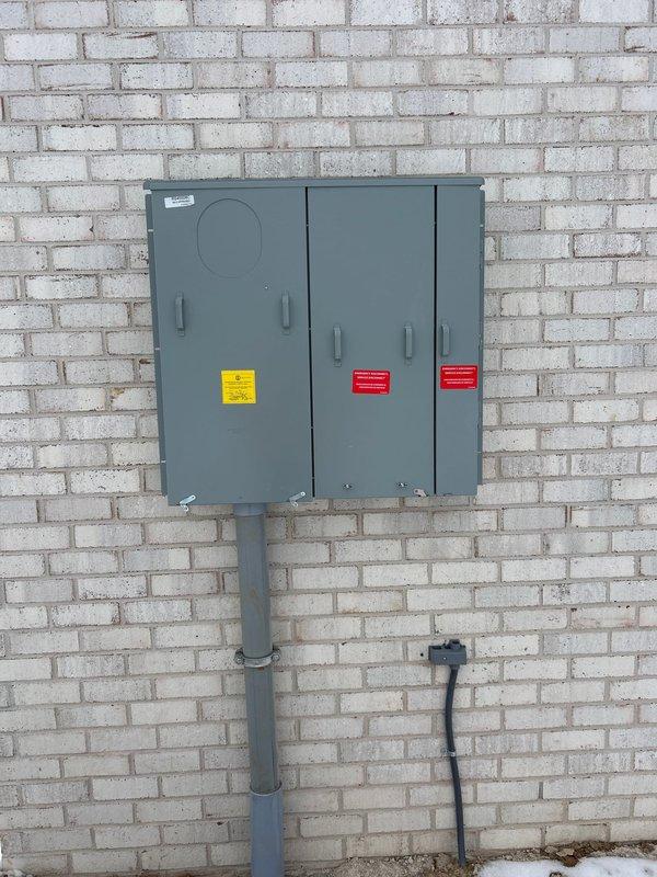 Conducted a comprehensive generator installation assessment, examining the existing dual circuit breaker panels with exposed internal components and evaluating the exterior electrical service panel mounted on brick wall. Documented current electrical infrastructure to determine appropriate generator specifications and connection requirements for the property.