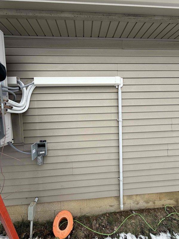 Completed installation of a 20K BTU mini-split system with dehumidification capability on residential property. Mounted outdoor condenser unit on exterior wall with proper elevation above ground level, installed line set with protective PVC covering, and connected electrical components including disconnect box. Indoor air handler was successfully mounted and all connections were completed according to manufacturer specifications.