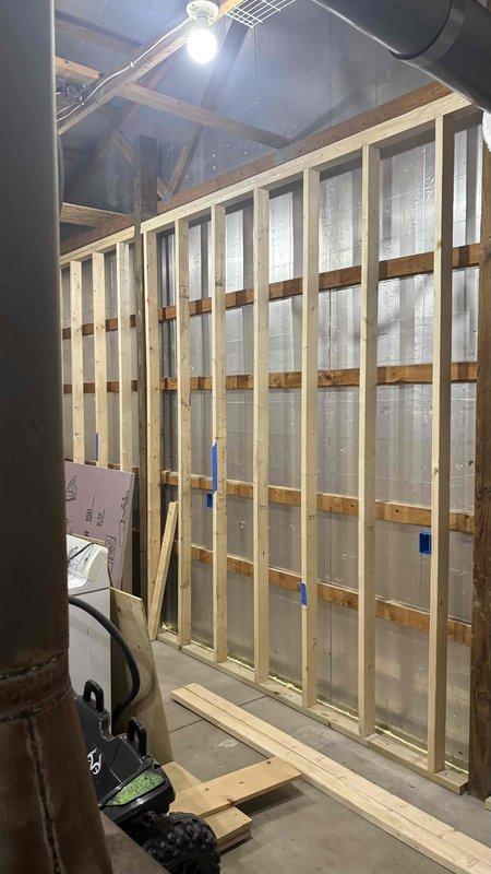 Conducted a mini-split system addition estimate for client's property currently under construction. Inspected framing area with exposed insulation to determine optimal unit placement. Evaluated exterior wall conditions for potential condenser location, noting adequate clearance and proper drainage considerations with existing snow conditions.