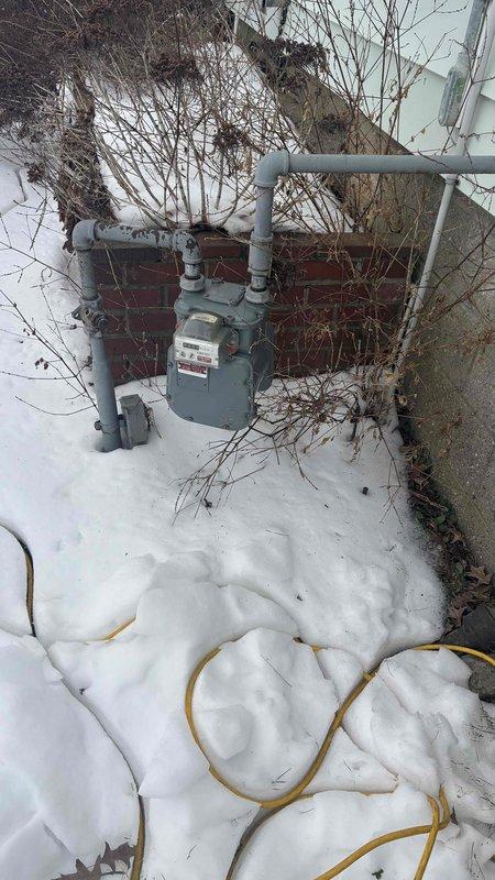 Performed inspection on non-functional HVAC system for customer Keaton Summers. Observed outdoor AC unit covered in snow with potential vegetation encroachment issues. Gas meter installation showed signs of shrub growth interfering with proper access and operation. Recommended full system replacement to restore heating functionality and address environmental hazards affecting equipment performance.