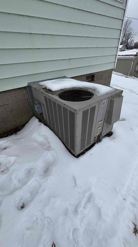 Performed inspection on non-functional HVAC system for customer Keaton Summers. Observed outdoor AC unit covered in snow with potential vegetation encroachment issues. Gas meter installation showed signs of shrub growth interfering with proper access and operation. Recommended full system replacement to restore heating functionality and address environmental hazards affecting equipment performance.