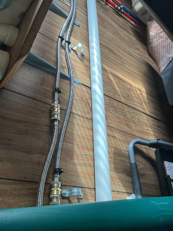 Responded to service call for washer hook-up completion. Installed PVC drainage system with proper wall mounting and connected washing machine drain hose. Completed water supply installation using flexible braided lines with brass fittings secured to wall. System is now operational with water service restored.