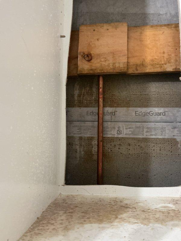 Performed leak search inspection in bathroom area. Located copper supply line within wall cavity requiring access through EdgeGuard moisture barrier. Utilized drain snake to investigate potential blockage in floor drain. Visual inspection revealed minor water spots/staining on decorative tile flooring, possibly indicating intermittent leakage. Further repair recommendations provided to customer.