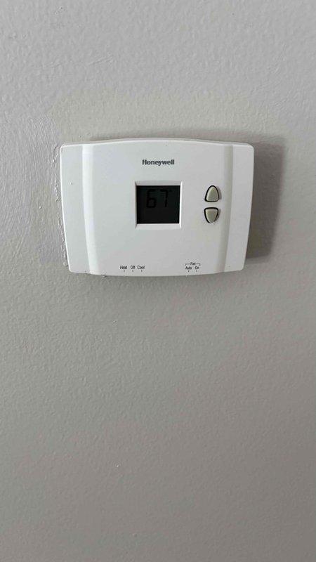 Conducted comprehensive replacement estimate for 20-year-old Gibson HVAC system in mobile home. Assessed existing outdoor unit showing signs of age and weathering, and inspected Honeywell thermostat currently maintaining interior temperature at 67°F. Customer specifically interested in replacement options with improved efficiency rather than repair alternatives, with no concerns about existing ductwork.