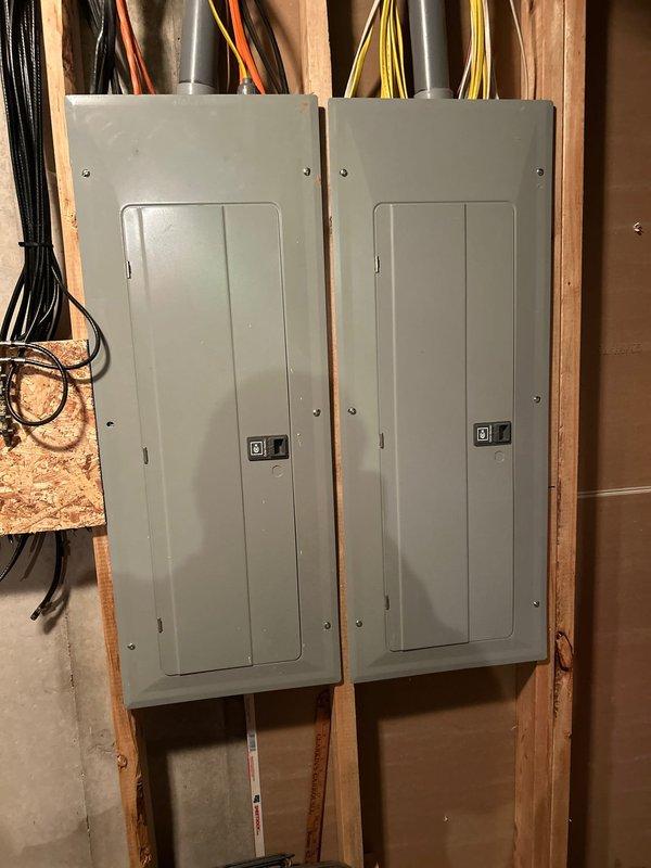 Conducted site assessment for generator installation at residential property with dual electrical panels mounted on exposed wooden studs in basement area. Client requires propane-fueled generator with new tank installation (existing tank located at north end of home). Noted 4-wheel drive vehicle access will be needed for installation. Client will be present during follow-up consultation.