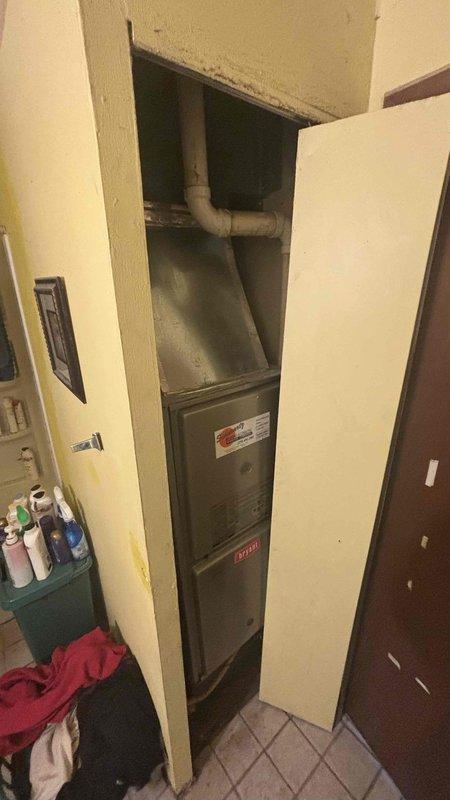 Conducted a detailed assessment of a downflow HVAC system for replacement estimate. Customer is experiencing reduced cooling performance from aging equipment and specifically interested in Trane systems. Documented existing installation measurements and configuration in utility closet, including furnace placement, ductwork connections, and base specifications for proper sizing of replacement equipment.