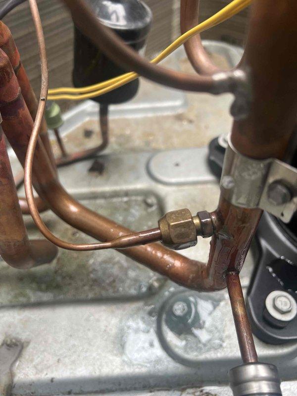 Completed follow-up leak detection service on HVAC system as requested in previous incomplete maintenance visit. Performed comprehensive inspection of copper refrigerant lines and brass fittings, focusing on connection points where oxidation was observed. System appears functional with normal wear on components; documentation includes detailed photographs of the refrigerant piping assembly for reference.