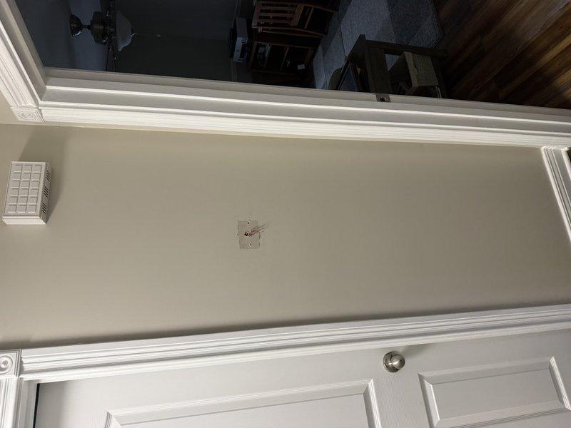Conducted site visit to evaluate thermostat relocation requirements. Identified optimal placement near the return air vent in living room as requested. Documented current thermostat location and proposed new location with photos for installation planning.