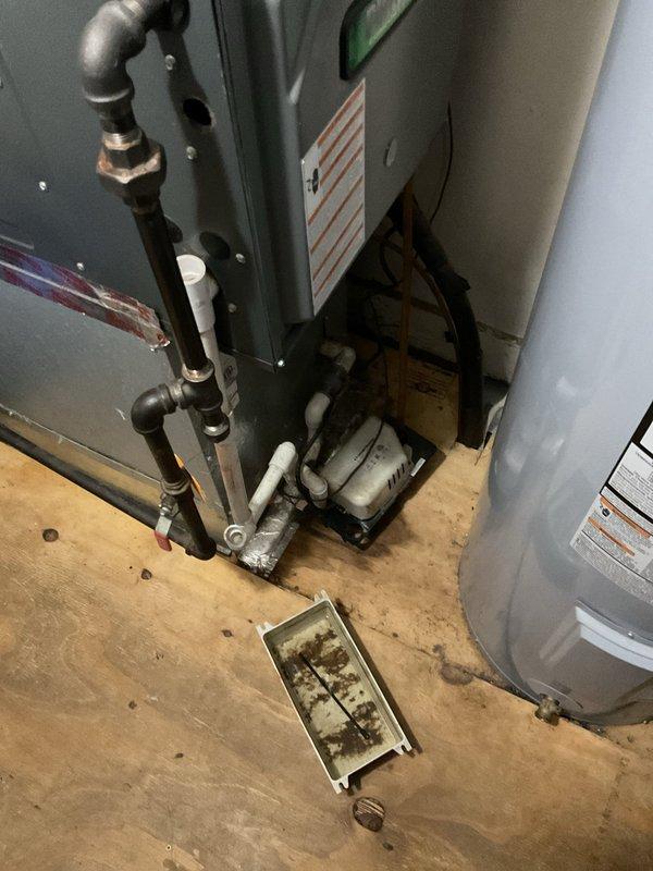 Responded to water leak report in utility room from a 6-year-old HVAC system. Upon inspection, identified a broken pipe on the furnace that had caused significant water release but had mostly stopped leaking at time of arrival. Documented the condition of the drainage pan showing sediment buildup and assessed potential water damage to the surrounding plywood flooring.