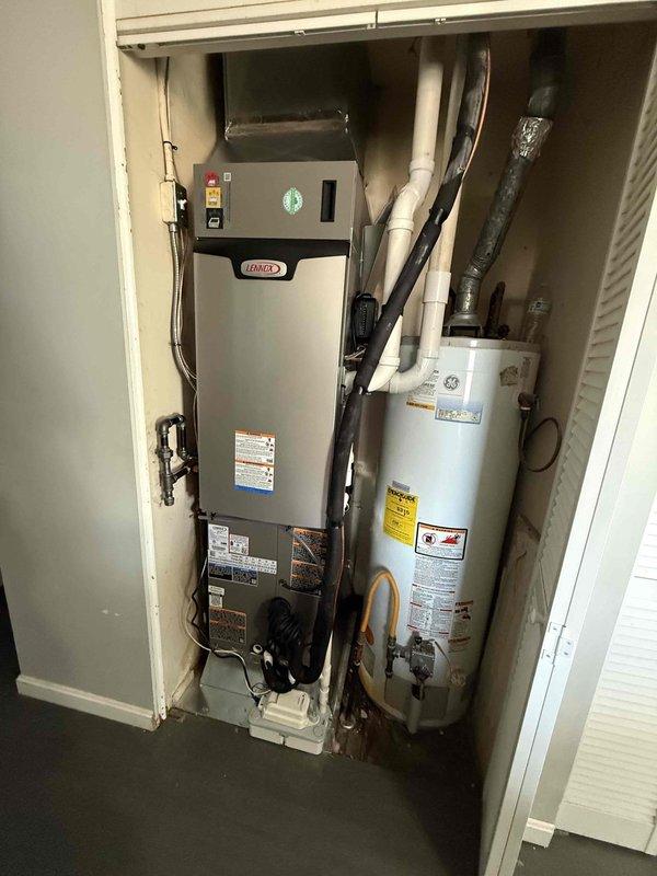 Successfully installed a complete Lennox HVAC system including outdoor AC unit mounted on concrete pad with proper PVC exhaust piping and electrical connections. Interior components include new Lennox furnace and associated ductwork installed in utility closet alongside existing water heater, with all systems tested and functioning properly.