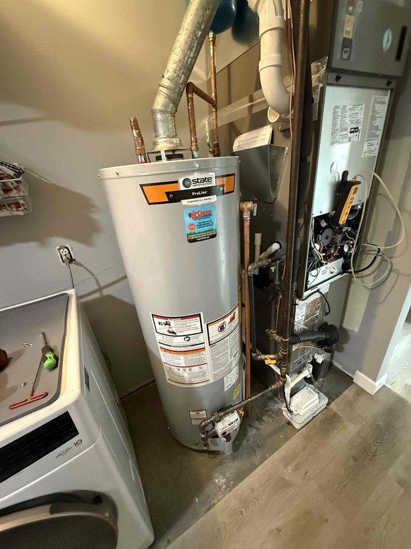 Completed installation of a 40-gallon State gas tall water heater in the utility area. Connected unit to existing copper and PVC plumbing systems, ensuring proper venting and gas line connections. Final inspection confirmed all components properly installed with no leaks or operational issues.