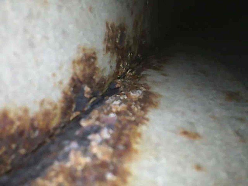 Performed Platinum Level maintenance on 25-year-old HVAC system with 20x25x5 filter. Identified significant water damage/rust staining at structural junction points. System appears functional despite age, with proper ventilation connections and no visible leaks from the furnace unit.