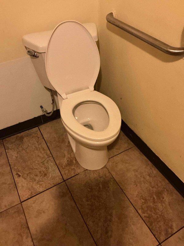 Responded to urgent water leak complaint at restaurant where water was flowing from building base. Upon inspection, discovered toilet leak in bathroom with accessible features. Repaired faulty toilet seal and inspected adjacent wall for water damage, noting minor staining that will require monitoring to ensure complete resolution of the issue.