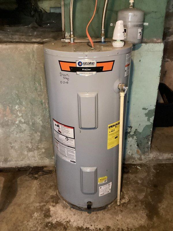 Conducted on-site evaluation of residential property, documenting the interior hallway layout and existing State Proline water heater installation. Noted current water heater setup includes copper supply lines, pressure relief valve, and appears to be installed in basement area with concrete floor and cinder block walls showing signs of deterioration, providing basis for HVAC replacement estimate.