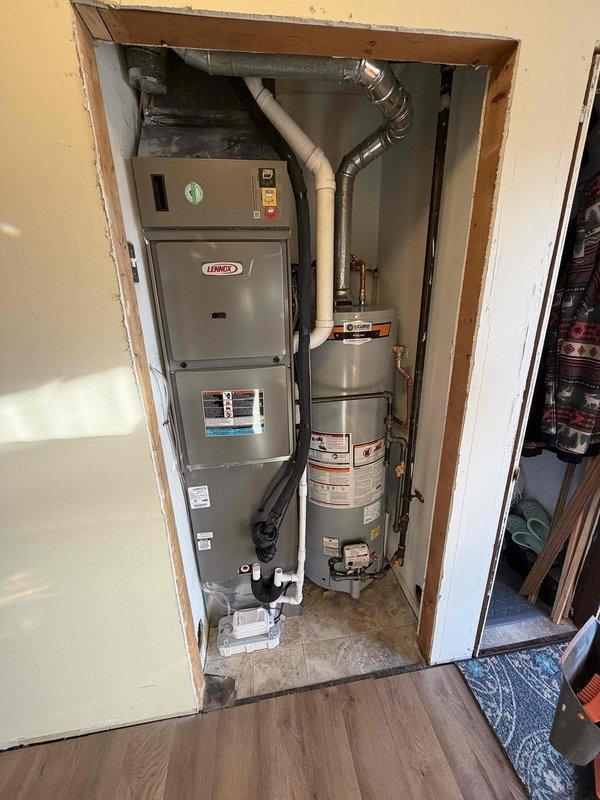 Successfully replaced corroded metal pipes with new PVC plumbing connections and installed a complete 2.5-ton 15.5 SEER 96% efficiency Lennox HVAC system. System was properly integrated with the existing water heater in the utility closet, with all necessary ductwork and drainage components installed according to manufacturer specifications.