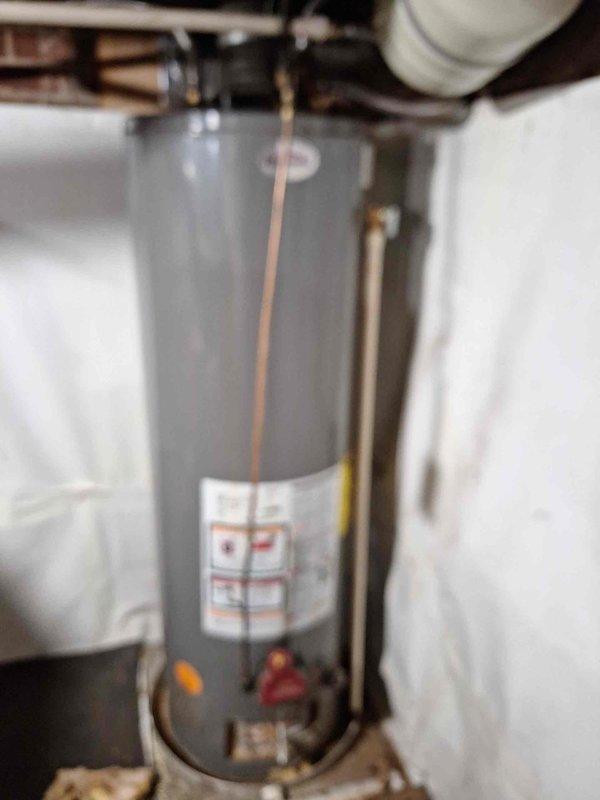 Conducted a comprehensive site assessment of the existing water heater system, documenting the standard residential unit with copper supply lines and control valves. Verified proper installation configuration and examined the unit for any potential issues, with photographic documentation provided for reference. No visible leaks, damage, or operational concerns were identified during the inspection.