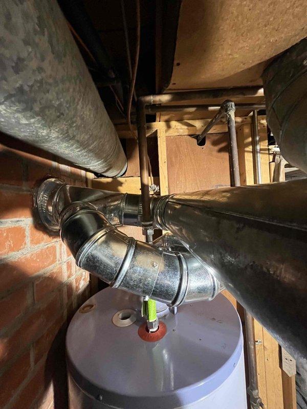 Installed new chimney liner in existing brick chimney which showed significant weathering and deterioration. Properly connected liner to existing HVAC system ductwork in basement, including necessary elbow joints and straight metal ducts. Completed installation with code-compliant chimney cap/vent hood to prevent water infiltration and ensure proper system ventilation.