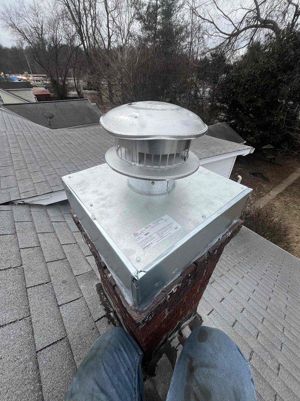 Installed new chimney liner in existing brick chimney which showed significant weathering and deterioration. Properly connected liner to existing HVAC system ductwork in basement, including necessary elbow joints and straight metal ducts. Completed installation with code-compliant chimney cap/vent hood to prevent water infiltration and ensure proper system ventilation.