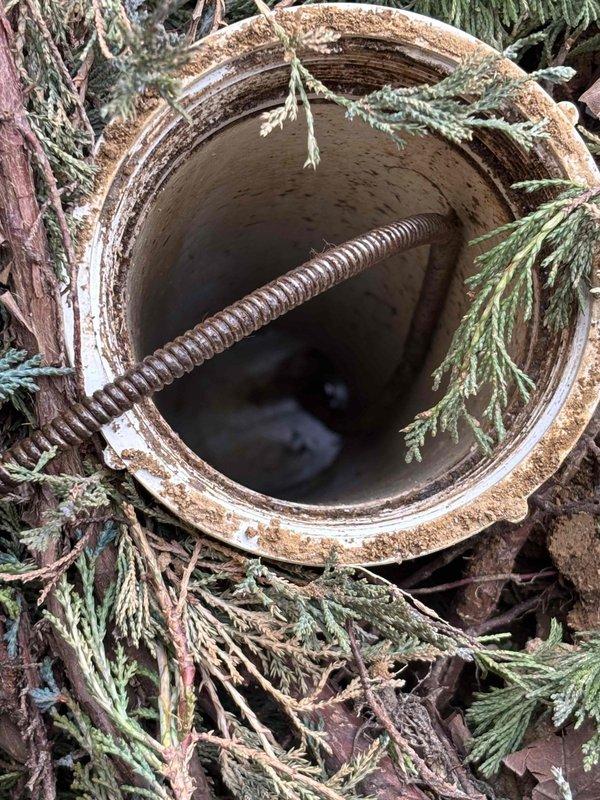 Conducted inspection of sewer system in response to reported cross-contamination between bathroom fixtures and strong sewage odor. Located and accessed outdoor sewer cleanout, revealing significant blockage in main line with standing water. Visual inspection of pipe interior showed deterioration of concrete walls with visible corrosion and sediment buildup, indicating potential need for line cleaning and possible pipe repair.