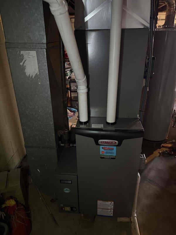 Installed a complete 2.5-ton Lennox HVAC system with 14 SEER condenser unit and 97% efficiency furnace. System includes properly connected PVC exhaust/intake venting and all necessary ductwork connections. Both indoor furnace unit and outdoor condenser were positioned and secured according to manufacturer specifications, with the outdoor unit mounted on a concrete pad adjacent to the residence.