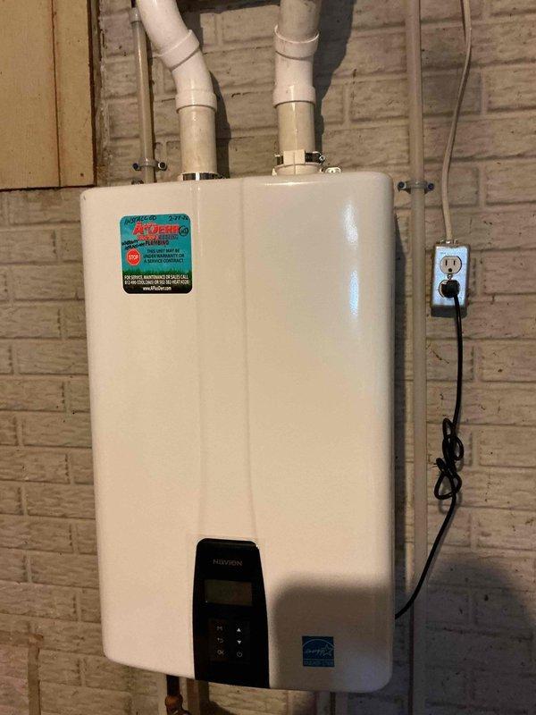 Performed warranty replacement of existing tankless water heater. Installed new unit on exterior wall with proper PVC venting and electrical connections. Internal inspection of previous unit revealed significant corrosion and rust damage on the bottom surface around drain points, likely contributing to failure. All connections were tested and system is functioning properly with no leaks detected.