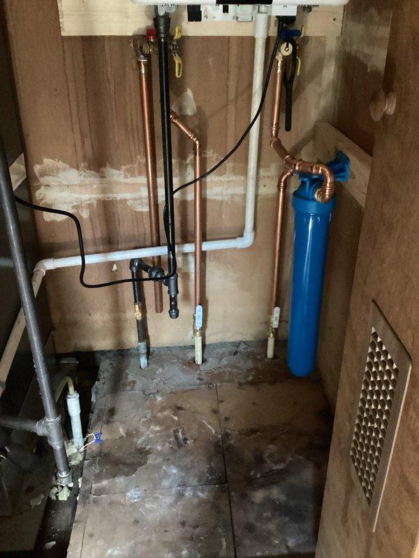 Successfully installed a Navien NPE-180A tankless water heater on a wooden wall with proper ventilation through PVC and metallic ducting. Installation included connecting copper, PVC, and drainage pipes to the unit and integrating it with an existing blue water filtration system in the utility room.