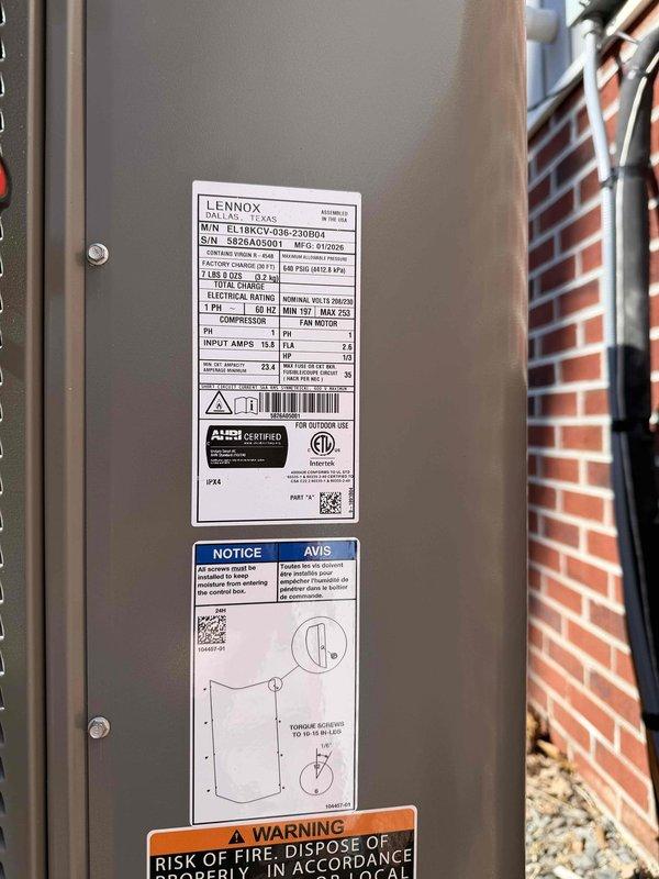 Installed new Lennox EL16XCV-036-230B04 complete HVAC system with outdoor condenser unit mounted on concrete pad adjacent to brick exterior wall. System includes proper refrigerant line connections, electrical wiring, and drainage setup with PVC drain pipe. Unit was tested and verified to be functioning according to manufacturer specifications.