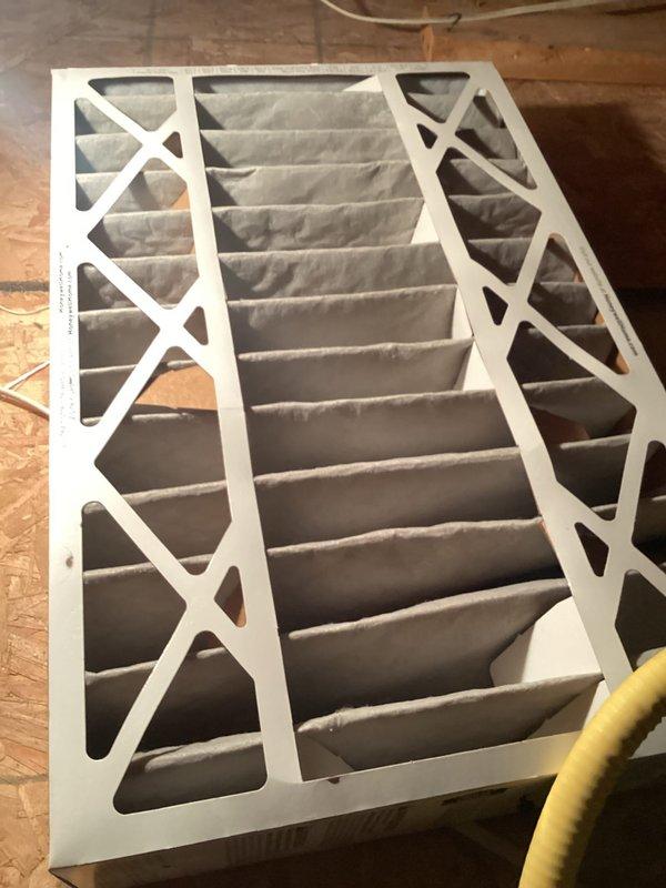 Performed routine AC tune-up on system of undetermined age. Inspected Honeywell digital thermostat for proper operation with temperature reading at 69°F. Examined air filter which showed normal usage patterns with slight discoloration but remains functional; filter has proper pleating with no significant airflow restrictions.