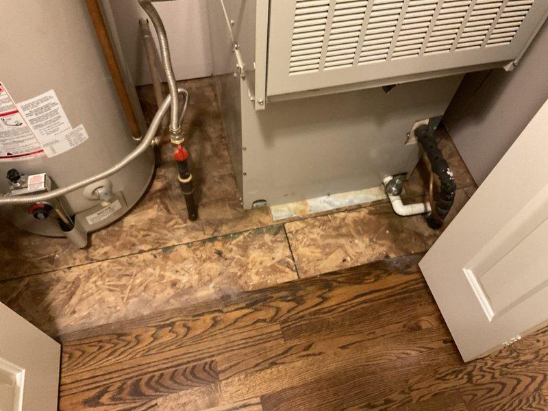 Conducted a comprehensive replacement estimate for converting an aging Arcoaire HVAC system to natural gas. Inspection revealed weathered outdoor AC unit installed on gravel base with visible weathering and discoloration. Interior mechanical room houses current water heater and HVAC equipment on partially finished flooring (transition between hardwood and OSB subflooring), indicating potential space considerations for new system installation.