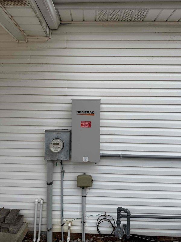 Completed inspection of generator installation per county requirements. Verified proper installation of Generac transfer switch box adjacent to utility meter with appropriate conduit connections. Confirmed generator placement on stone bed with correct clearances from HVAC equipment and proper electrical connections to the transfer switch system.