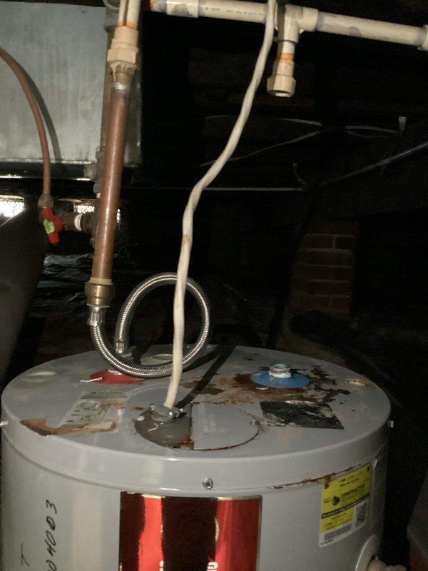 Inspected 120-year-old home's water heater system exhibiting active leakage. Observed significant corrosion and deterioration at the top of the tank with compromised connections to both the PVC vent pipe and copper supply lines. Replaced failed water heater unit, ensuring proper installation of all plumbing connections and verification of system functionality.