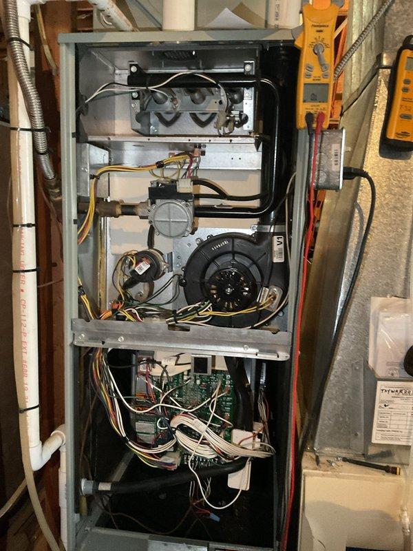 Performed annual first visit maintenance on two aging HVAC systems (19 and 21 years old) with Gold Level service plan. Inspected and serviced both furnace units, including examination of blower motor assembly, circuit boards, gas valve components, and all electrical connections. Replaced air filters (April Aire 2200 and 2400) and noted water heater shows signs of previous leakage with mineral deposits visible at base.