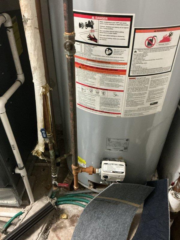 Performed site visit to inspect recertification pump system. Documented existing water heater installation showing signs of wear including damaged pipe insulation and corrosion on copper pipes and fittings. Noted significant oxidation on plumbing components, particularly at joints, with visible rust streaks on galvanized metal ductwork requiring attention during recertification process.