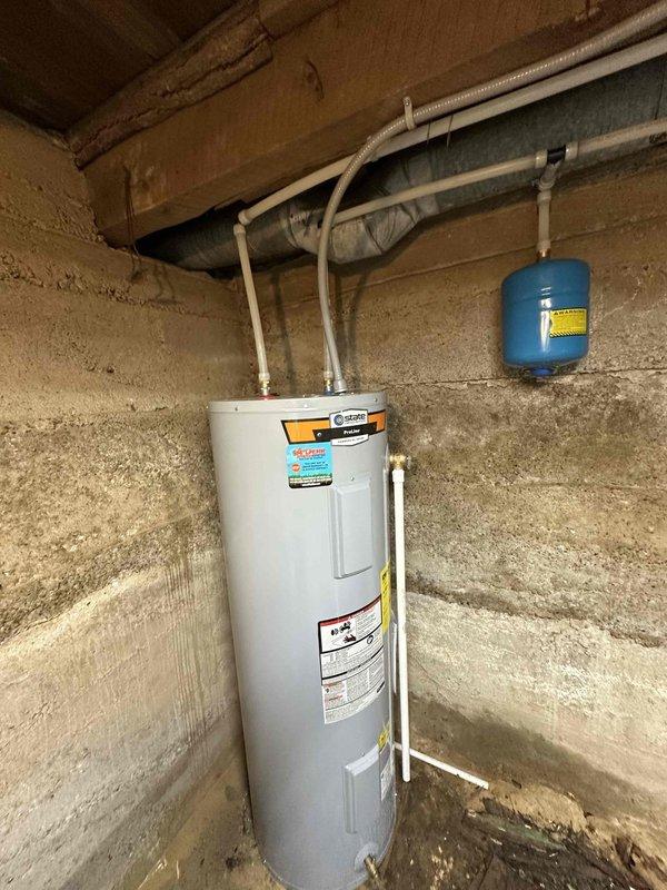 Successfully installed a new 50-gallon electric water heater in basement utility area, including proper connection of supply lines and installation of expansion tank. Unit was securely positioned against concrete wall with all manufacturer specifications verified and safety protocols followed.