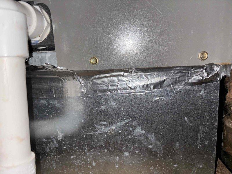 Identified unsealed joints and unsecured bracket in indoor utility closet HVAC system, causing air leakage at multiple connection points. Applied metallic tape to seal exposed seams on galvanized ductwork and properly secured mounting hardware on the main housing panel to restore system integrity and prevent further air loss.