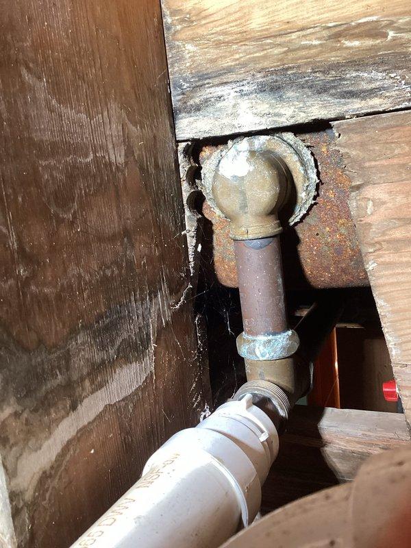 Performed inspection of shower plumbing leak reported in crawl space. Identified severely corroded galvanized pipe with significant rust damage at connection point to PVC. Documented evidence of water intrusion through wooden structural elements for real estate disclosure purposes.