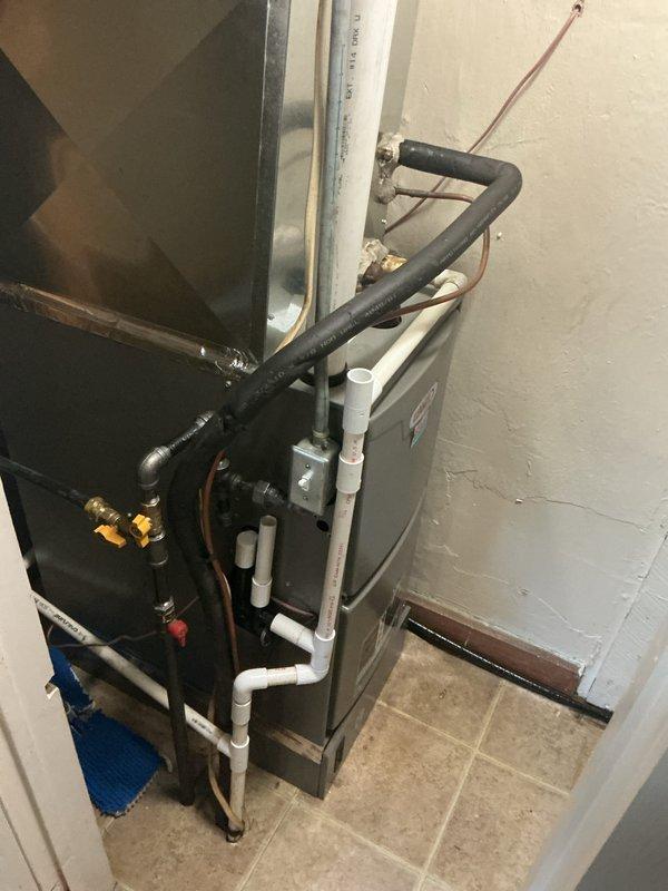 Completed annual maintenance on residential HVAC system. Inspected furnace unit, refrigerant lines, and electrical connections using level tool to verify proper equipment alignment. System appears to be in normal working condition with no visible damage or leaks detected.