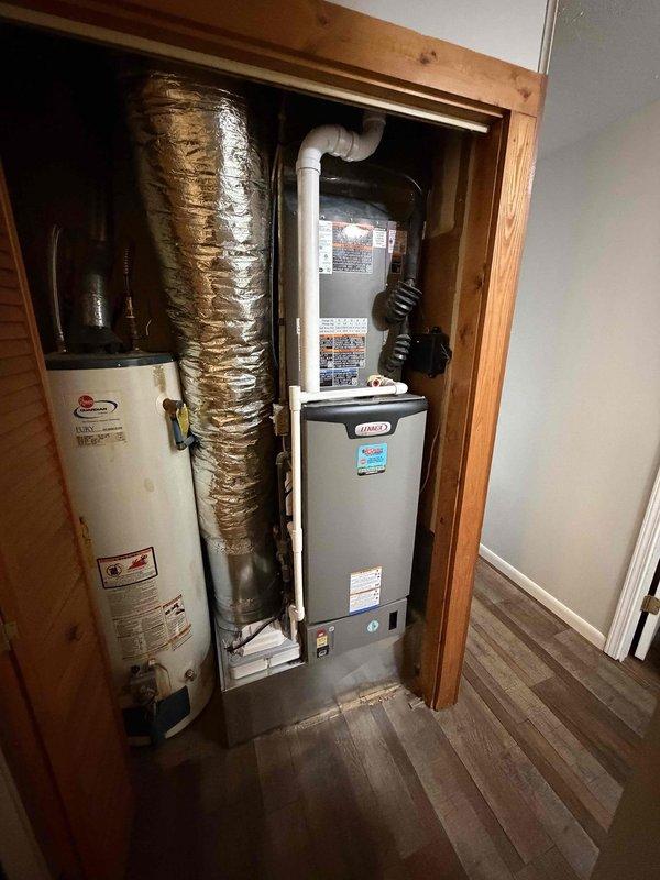 Successfully installed a complete 2.5 ton, 15.5 SEER Amana HVAC system in the utility closet of the residence, including proper connection of ductwork with reflective insulation and PVC ventilation piping. System includes new air return vent installed on interior wall with all components verified operational.