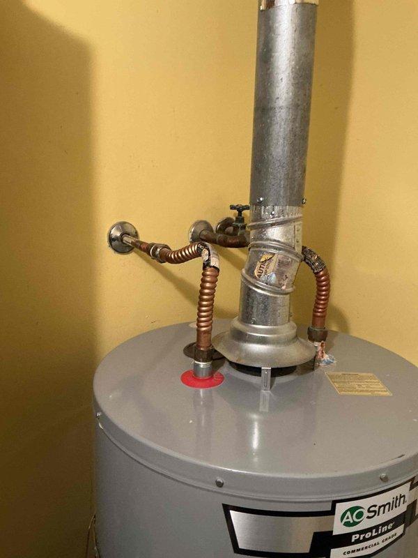 Performed scheduled annual maintenance on a 1-year-old AO Smith ProLine tanked water heater, completing the second maintenance visit since installation. Successfully flushed the system to remove sediment buildup, inspected all connections and verified proper venting through the galvanized exhaust flue. Noted some water pooling on exterior concrete walkway, which was documented with photos.