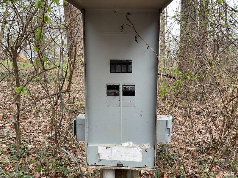 Completed site assessment for whole home generator installation. Documented existing electrical service panel mounted outdoors in wooded area showing signs of weathering with vegetation growth nearby. Evaluated utility pole installation with meter connection to determine appropriate generator sizing and placement options for future whole home backup power system.