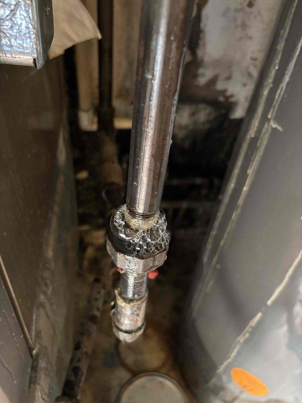 Responded to a gas leak call for a 2010 HVAC system. Upon inspection, identified corrosion at pipe joint connections in the utility room, with visible signs of moisture and deterioration at the copper pipe and fitting assembly. Repaired the faulty connection point that was causing the intermittent gas odor detectable upon entering the room.