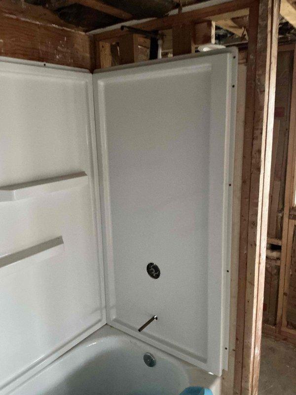 Successfully installed a fiberglass shower/tub enclosure in a bathroom under renovation. Properly mounted the unit within the wall framing and completed all necessary plumbing connections, including drain pipe and water supply lines secured with appropriate brackets. All components were installed according to code with proper alignment and secure fastening to ensure functionality.
